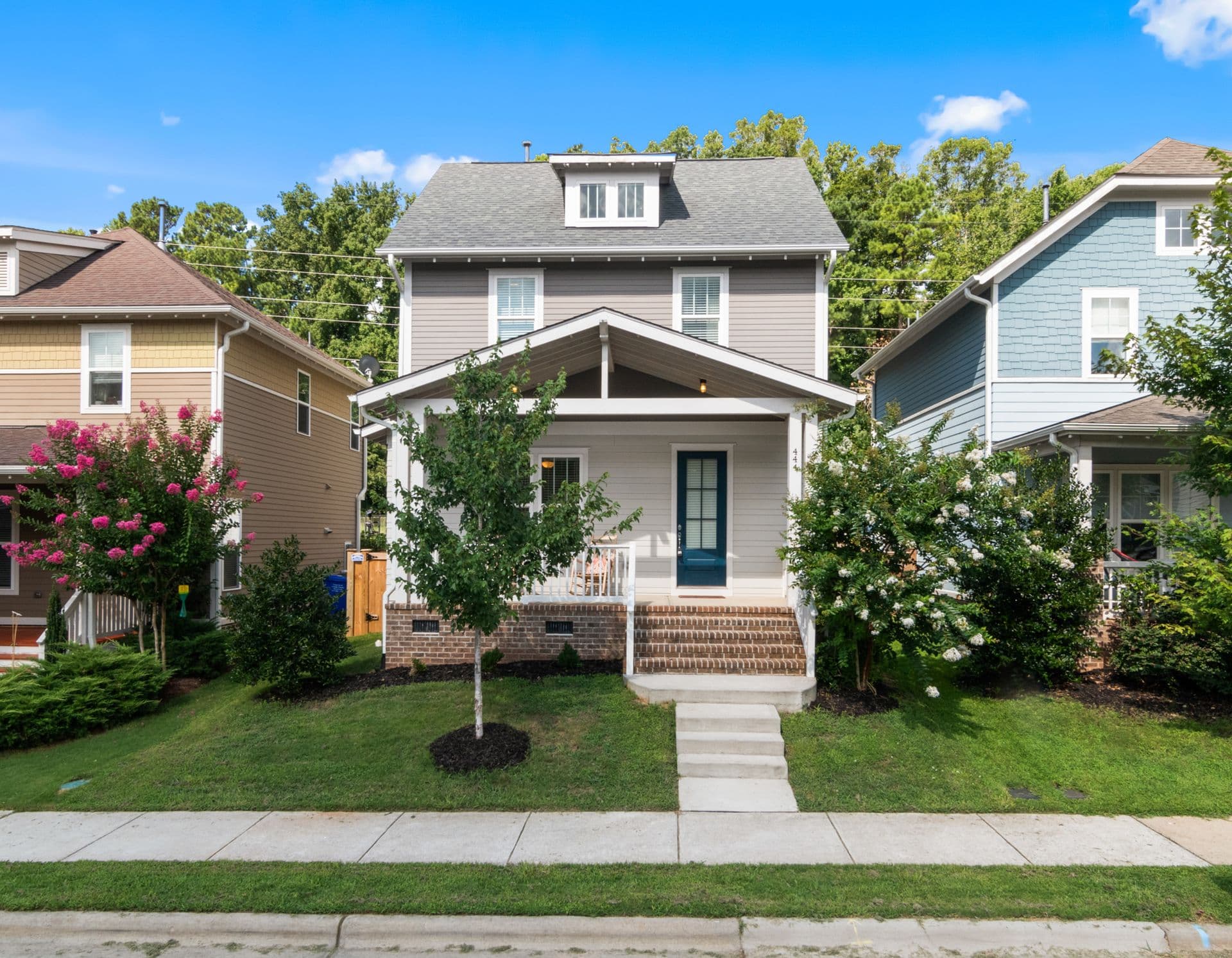 Two-story home with gray lap siding, white trim, and a blue front door